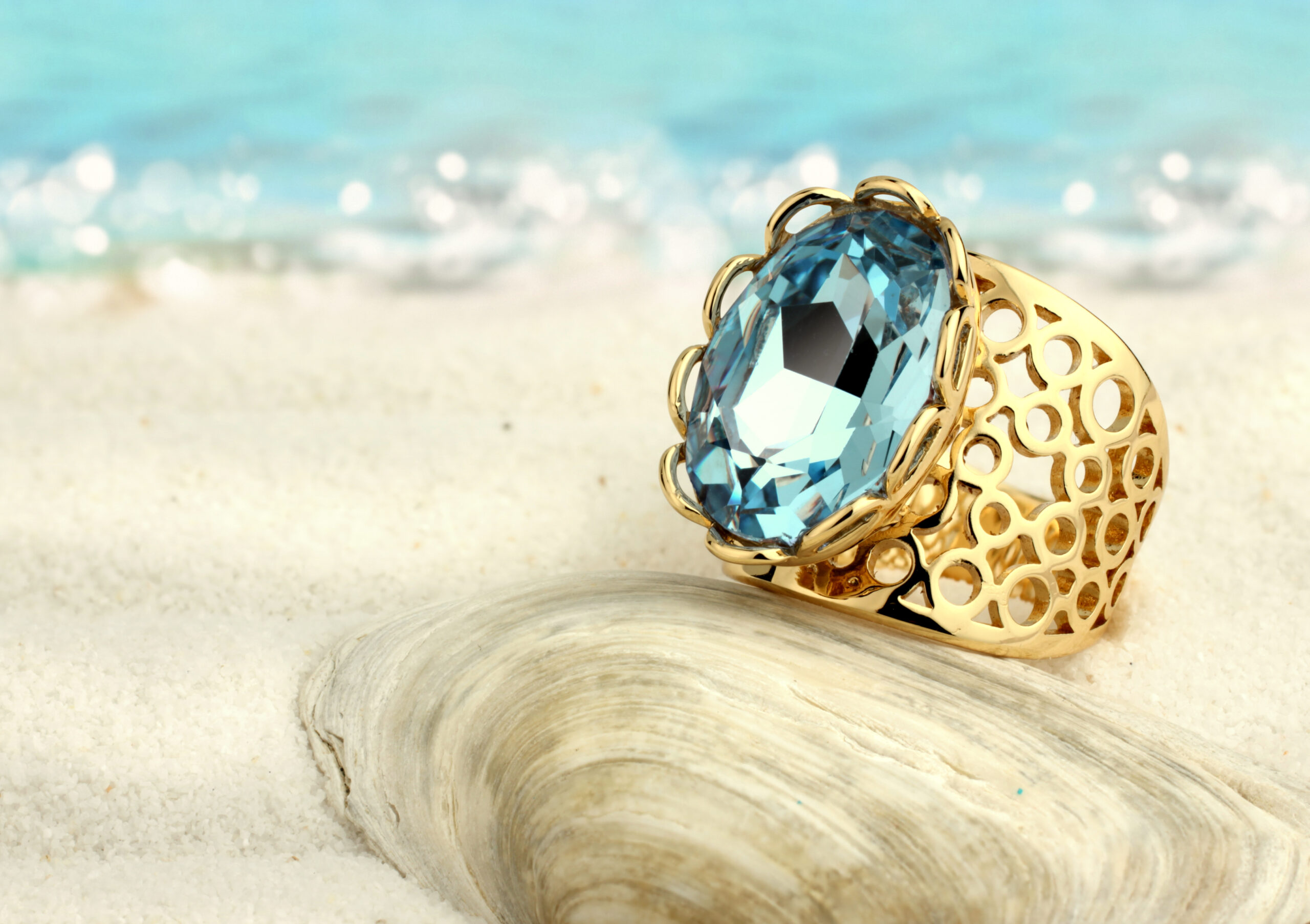 Golden,Ring,With,Aquamarine,On,Summer,Sand,Beach